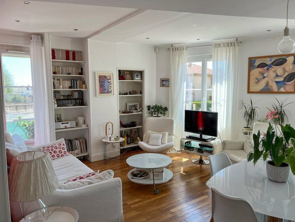 living room with wood floors and white furniture