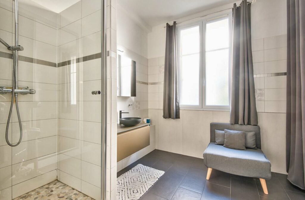 bathroom with white tiling and standing shower