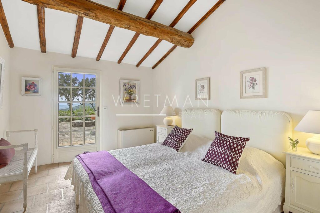 bedroom with two single beds with purple pillows and white bed frame