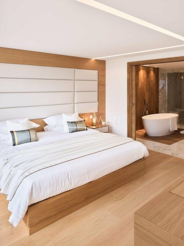 bedroom with king size bed with white bedding and wood bedframe