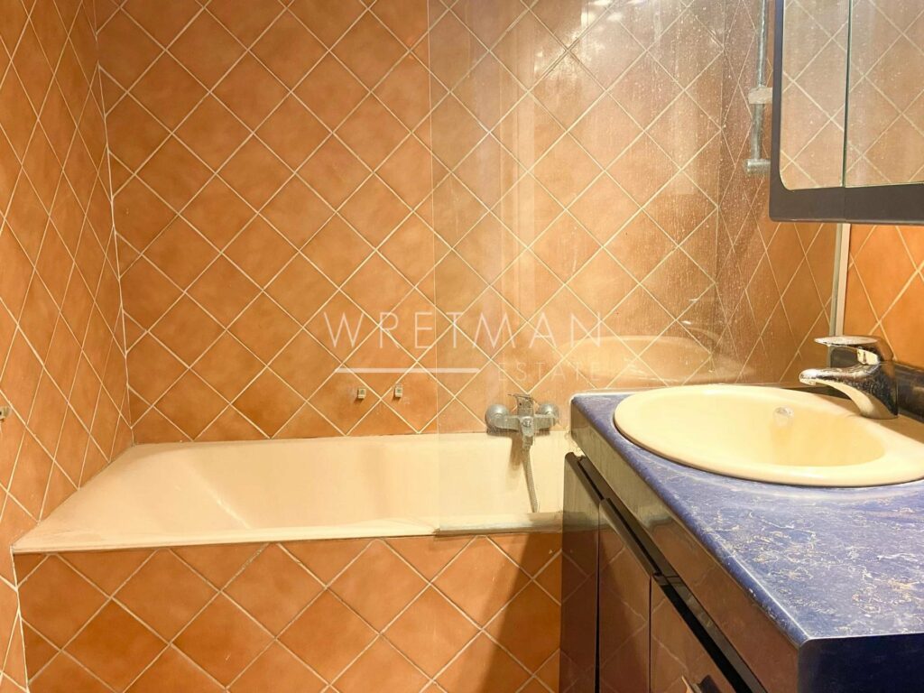 bathroom with bath tub and beige tile design