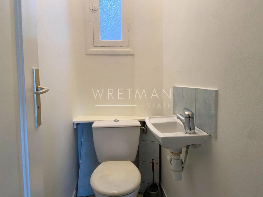 toilet room with all white interior and small sink in corner