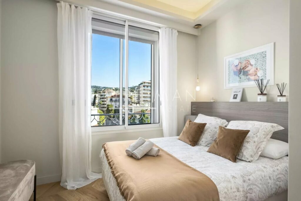 bedroom with queen size bed next to window with city view