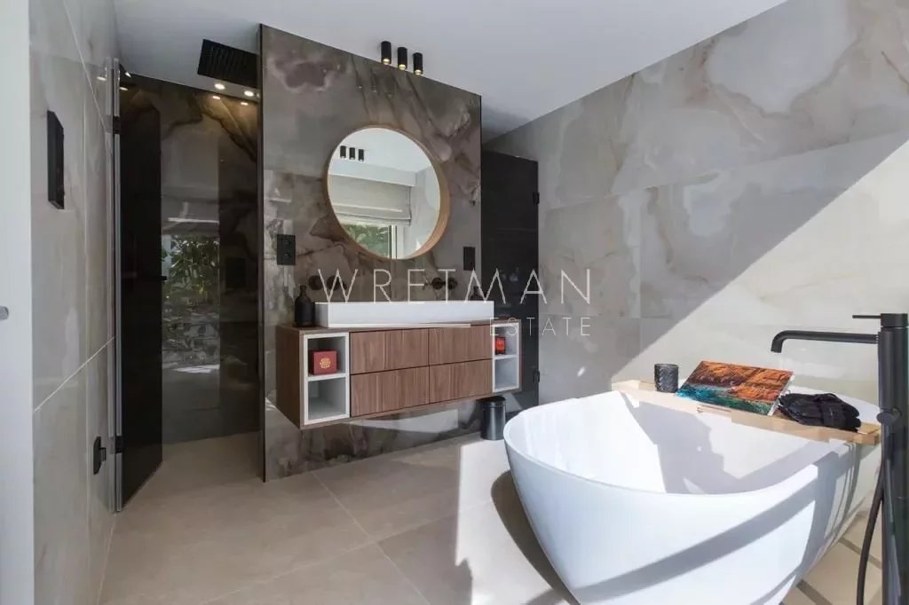bathroom with brown marble walls and large round mirror