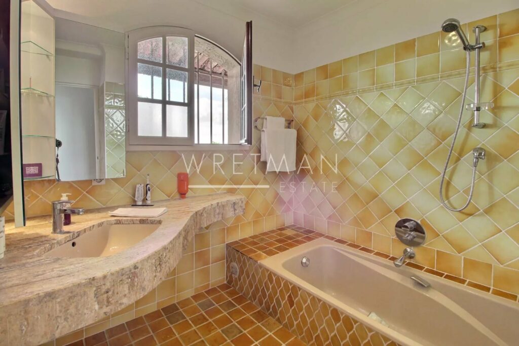 bathroom with yellow tiling and low bath tub
