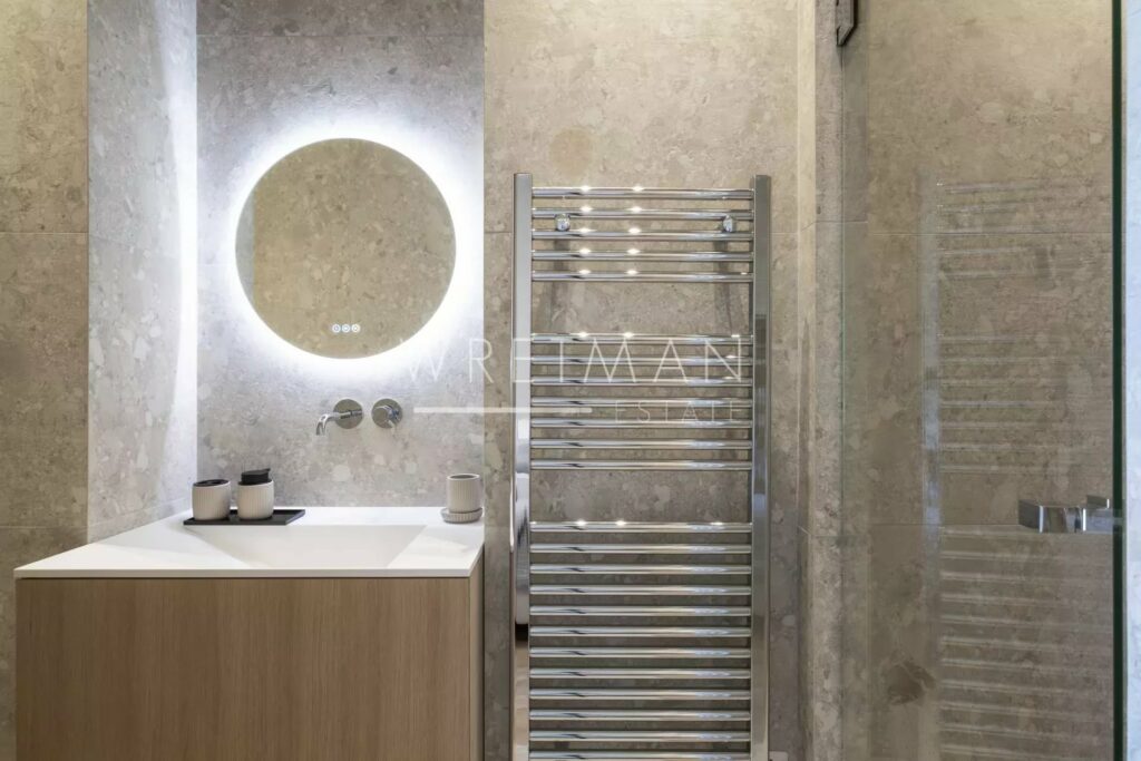 modern shower room with large round mirror above mirror