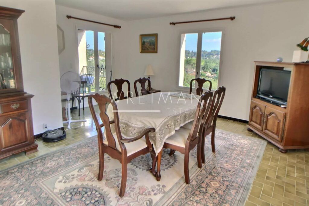 A sunlit dining area with a view of the garden in the Chateauneuf villa.