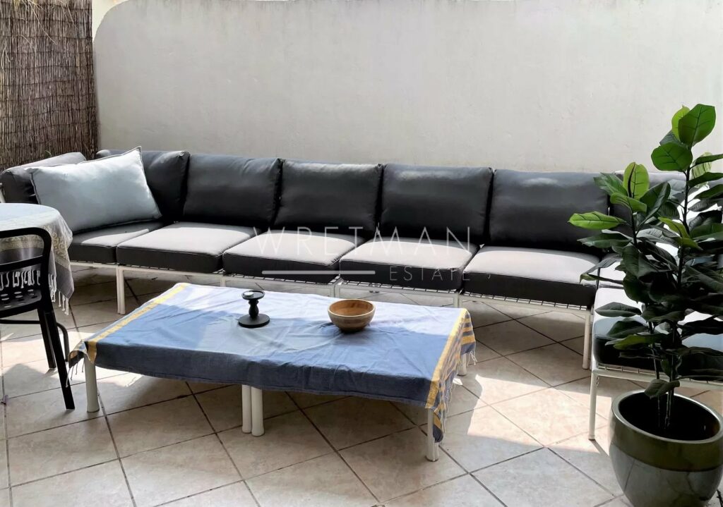 outdoor patio area with large couch and white tile floors