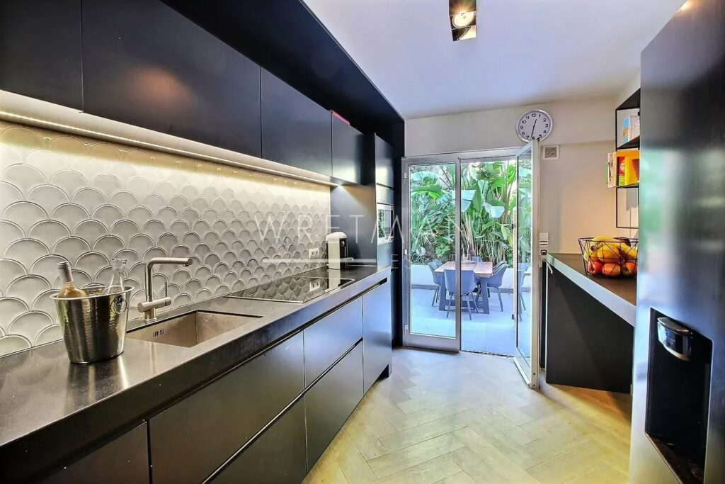 modern kitchen with black cabinets and access to patio