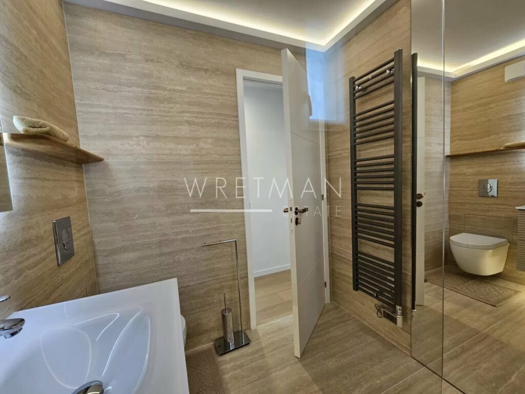 modern bathroom with brown tiling and towel warmer